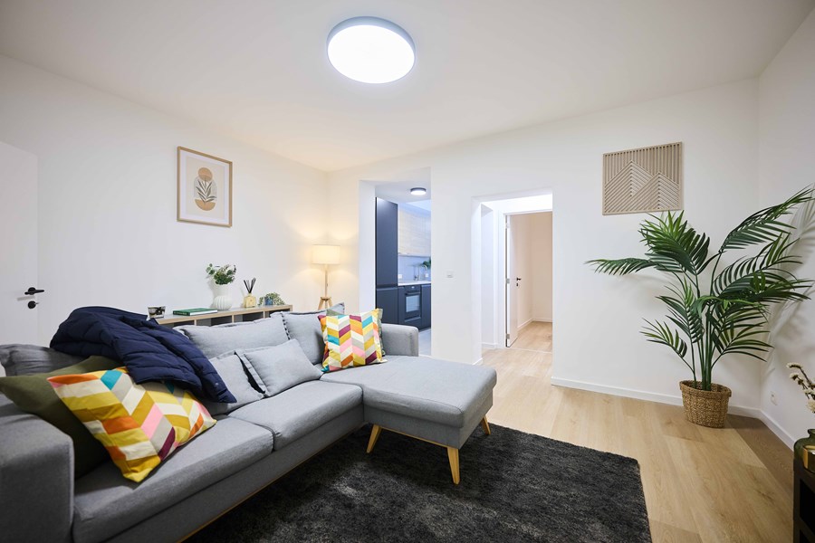 Salon confortable avec canapé en L dans la colocation Hellebaut 26