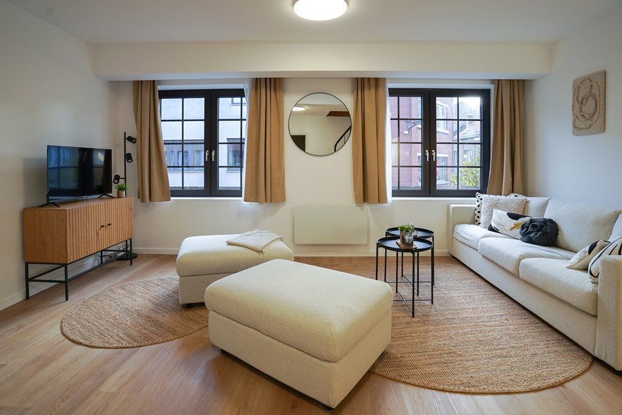 Salon convivial avec canapé et poufs dans la colocation Résistance 45